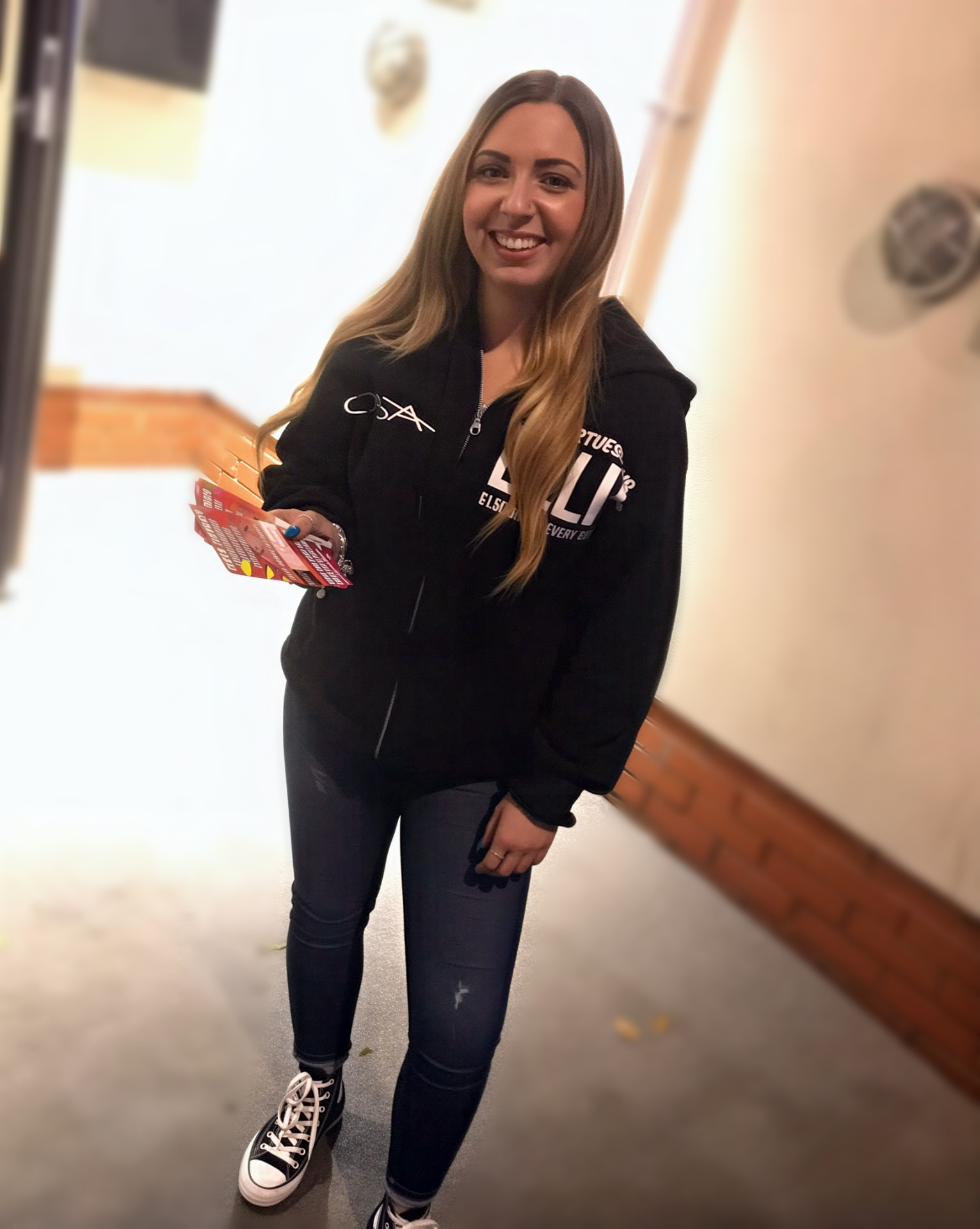 Woman handing out A5 promotional flyers during a leaflet distribution campaign